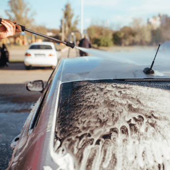 an image of a man power washing a car 