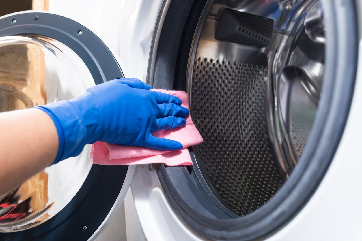 an image of someone cleaning the inside of a washing machine