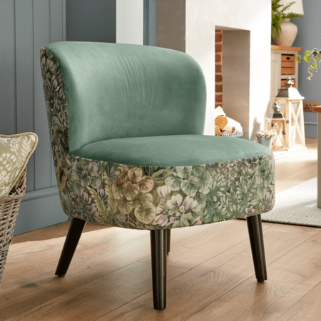 Large green chair with floral sides and brown legs.
