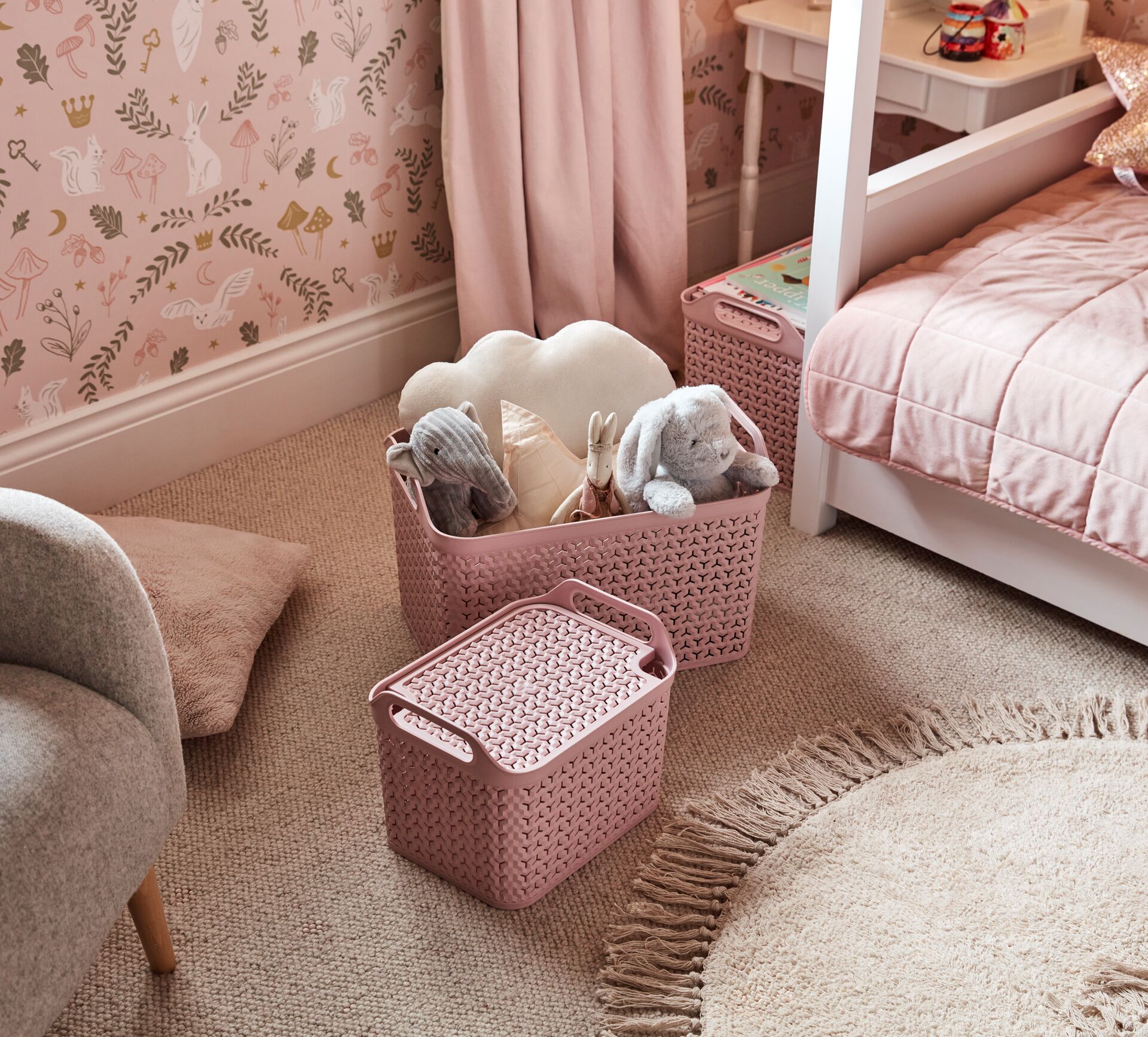 Photograph of two pink woven toy storage boxes in a child's bedroom