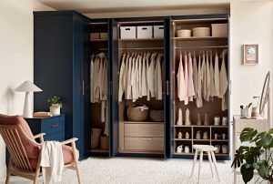 Navy blue fitted wardrobe with the doors open, revealing hanging rail, storage boxes and shoe rack inside