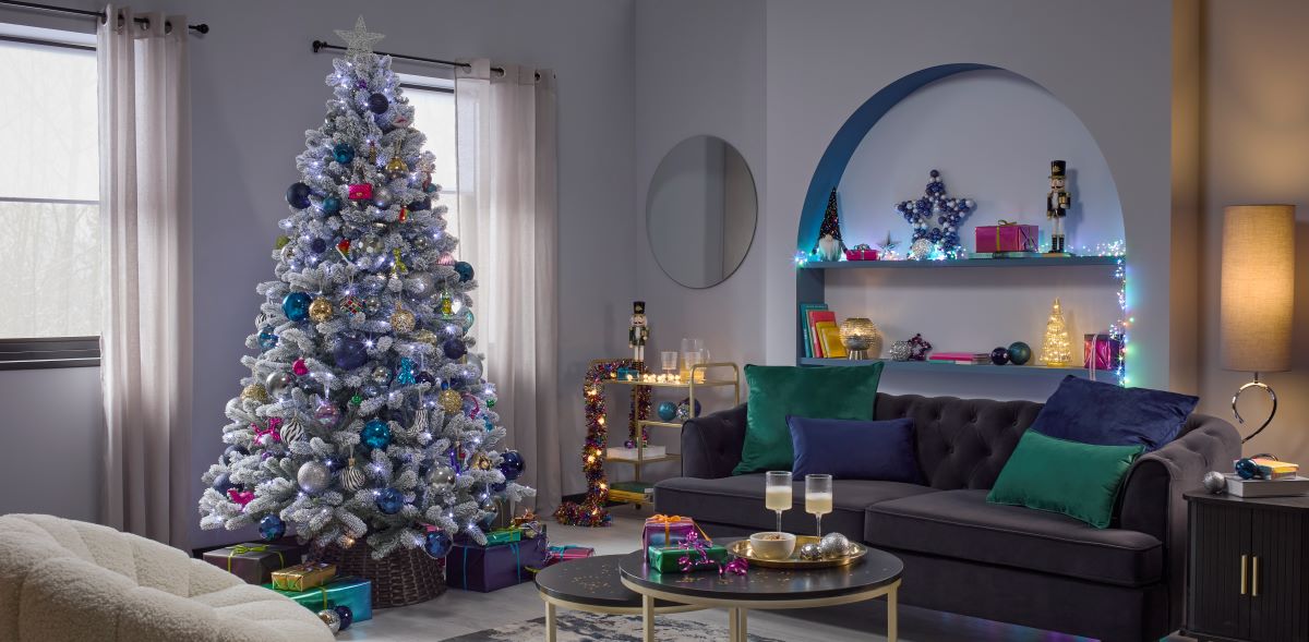 A pale blue and navy living room decorated with a Christmas tree and disco-themed ornaments.