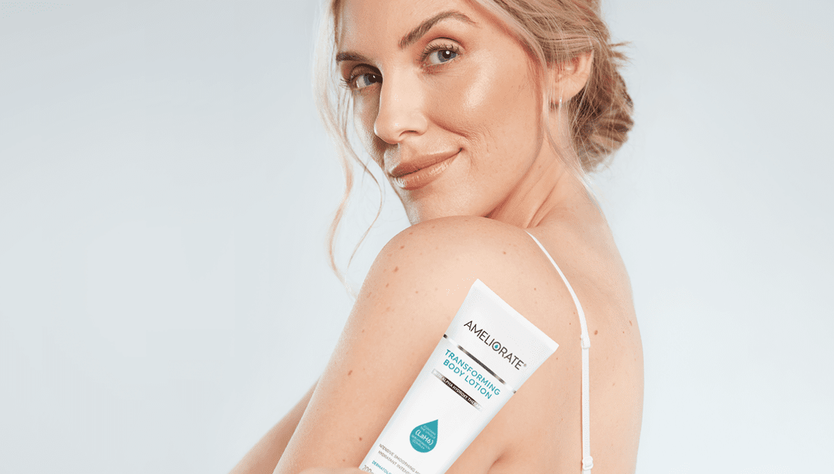 blonde model holding Ameliorate transfoming body lotion over shoulder