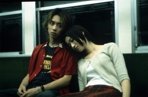 A woman rests her head on her companion's shoulder in Pulse (2001)
