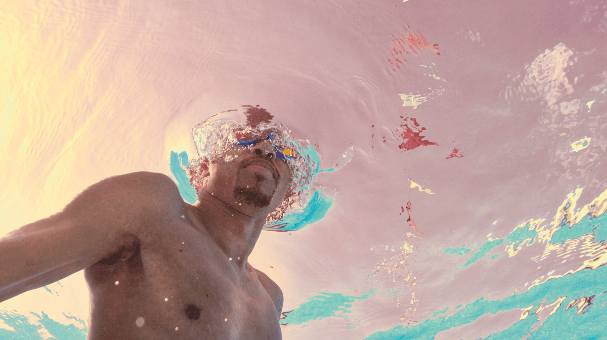 A man swimming wearing Speedo goggles