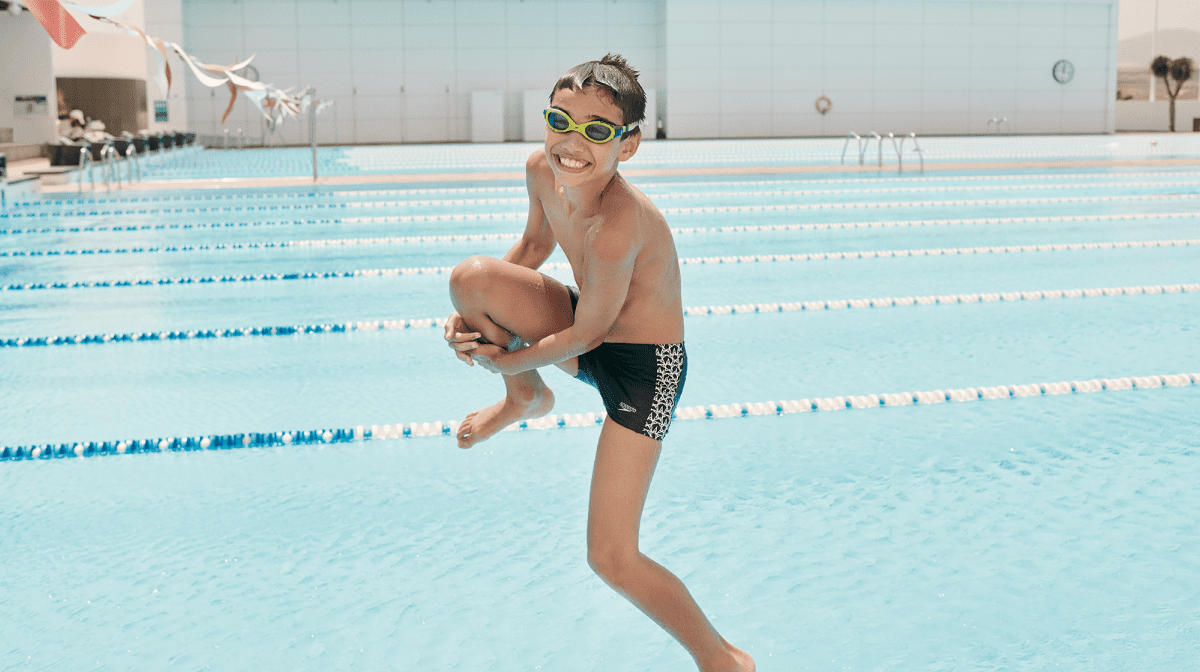 A kid jumping into a pool on holiday