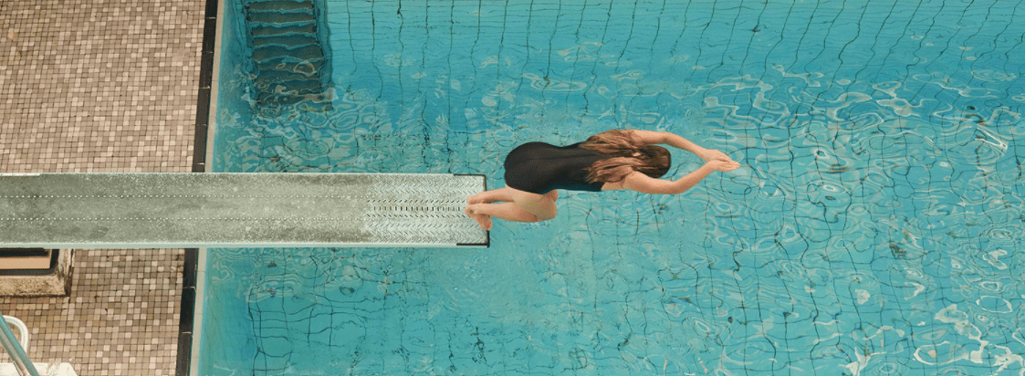 A woman jumping off a diving board into water