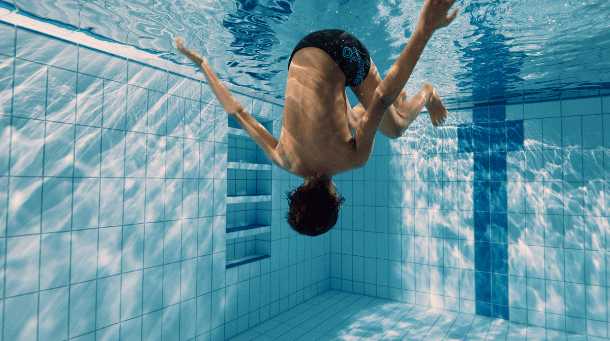 A child performing a flipturn in a swimming pool