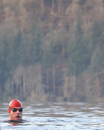 Man swims in lake in Speedo swimwear