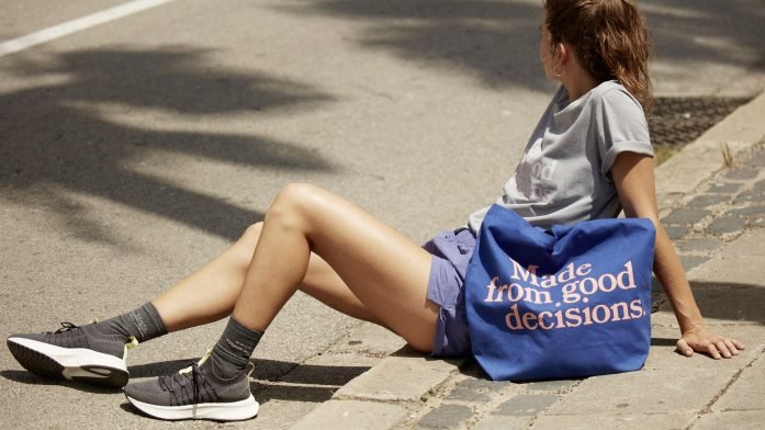 photo of a woman sitting down on a kerb wearing running gear