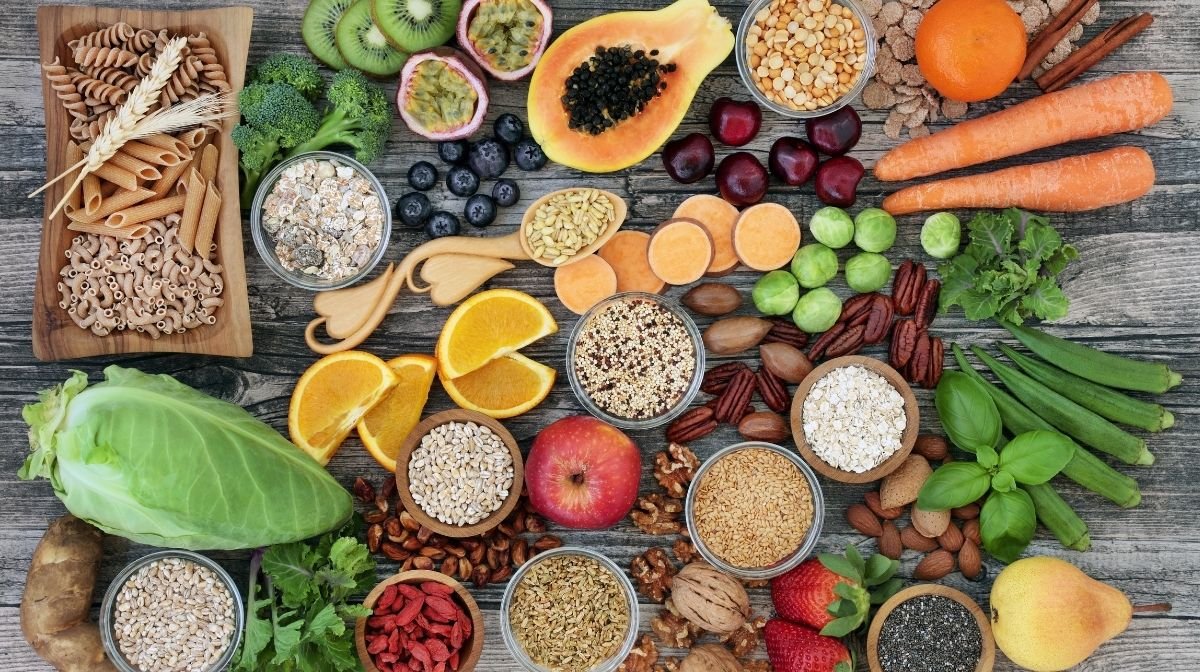 Un tavolo coperto con frutta, semi e verdure che aiutaro il nostro sistema digestivo a rimanere forte e in salute