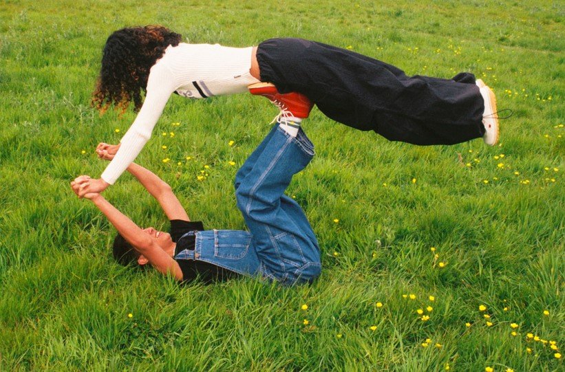 Photgraph of two children playing in a grassy field wearing Kickers shoes