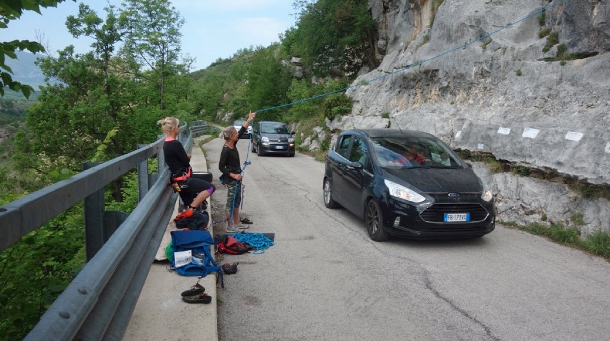 Climbers lift cables over cars in Italy