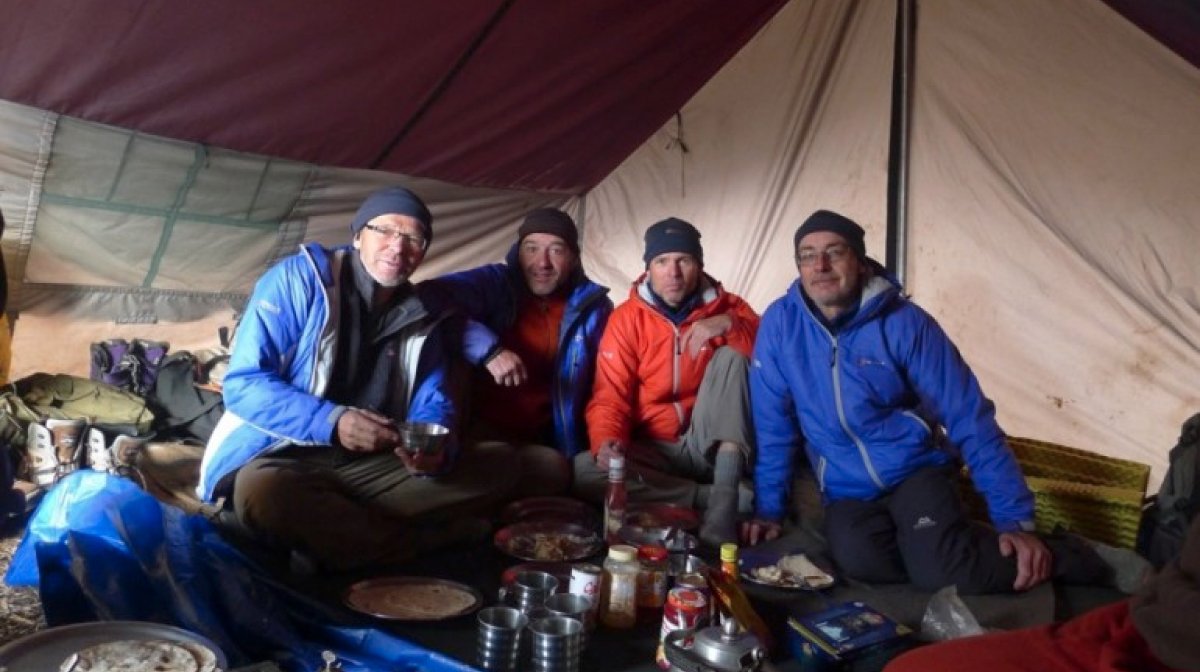 Team enjoys meal in a tent