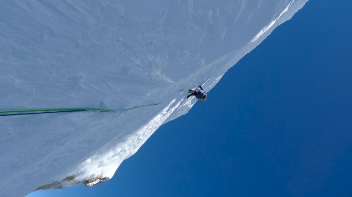 Climber ascends icy cliff