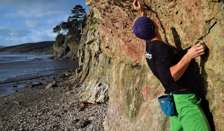 boulderer navigating steep rock face