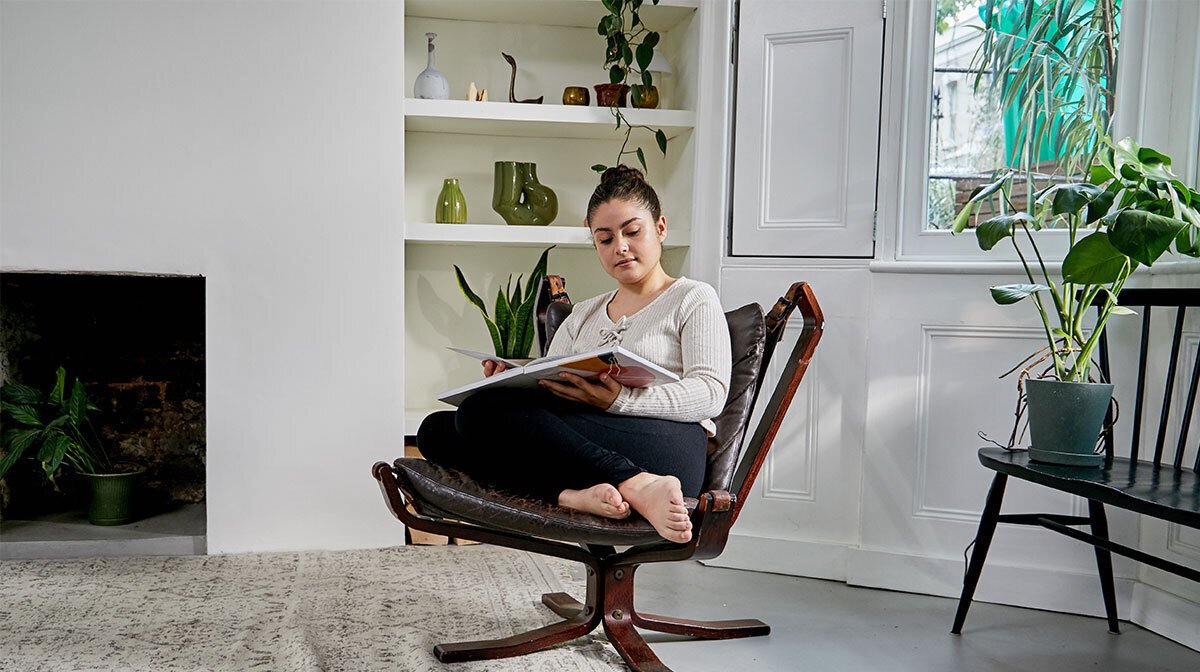 Woman relaxing reading box on armchair 