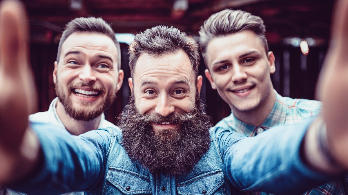 Three men take smiling selfie
