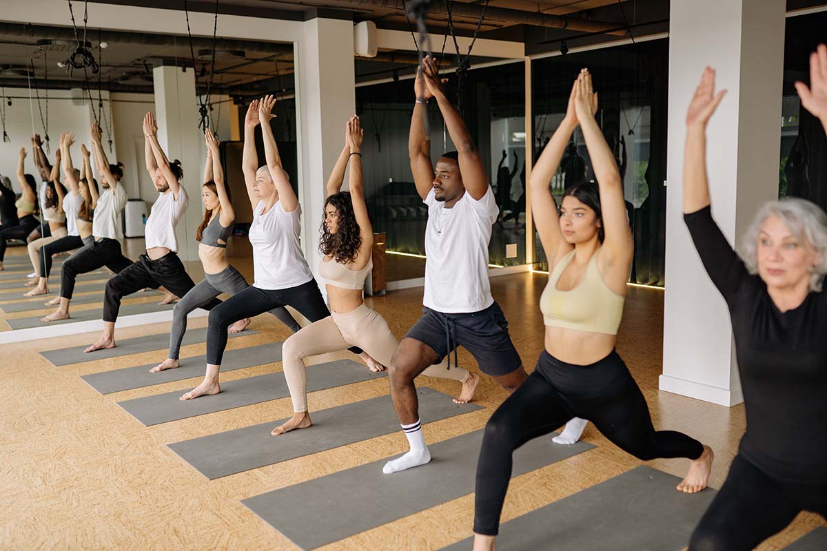 Variety of men and women, of all ages, doing yoga in a class