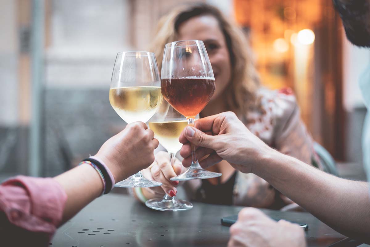 three women toasting with full wine glasses 