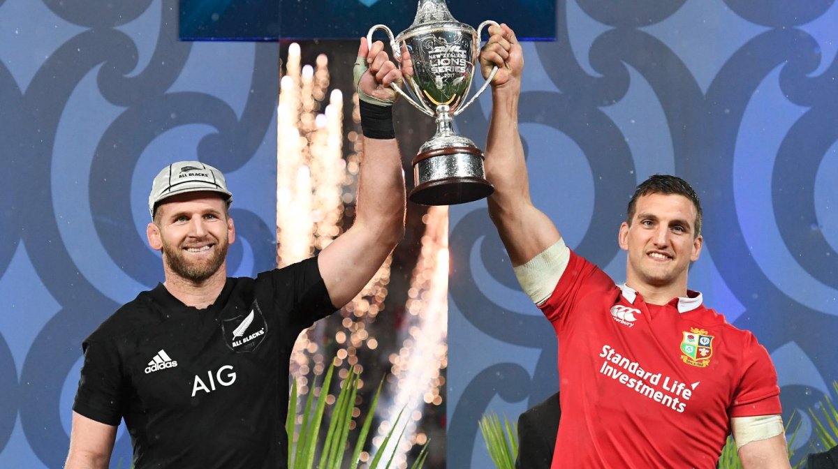 Lions and All Blacks players hold trophy together
