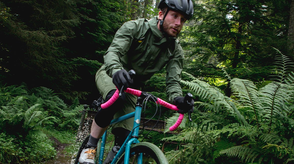 Man cycles through forest in Endura waterproof