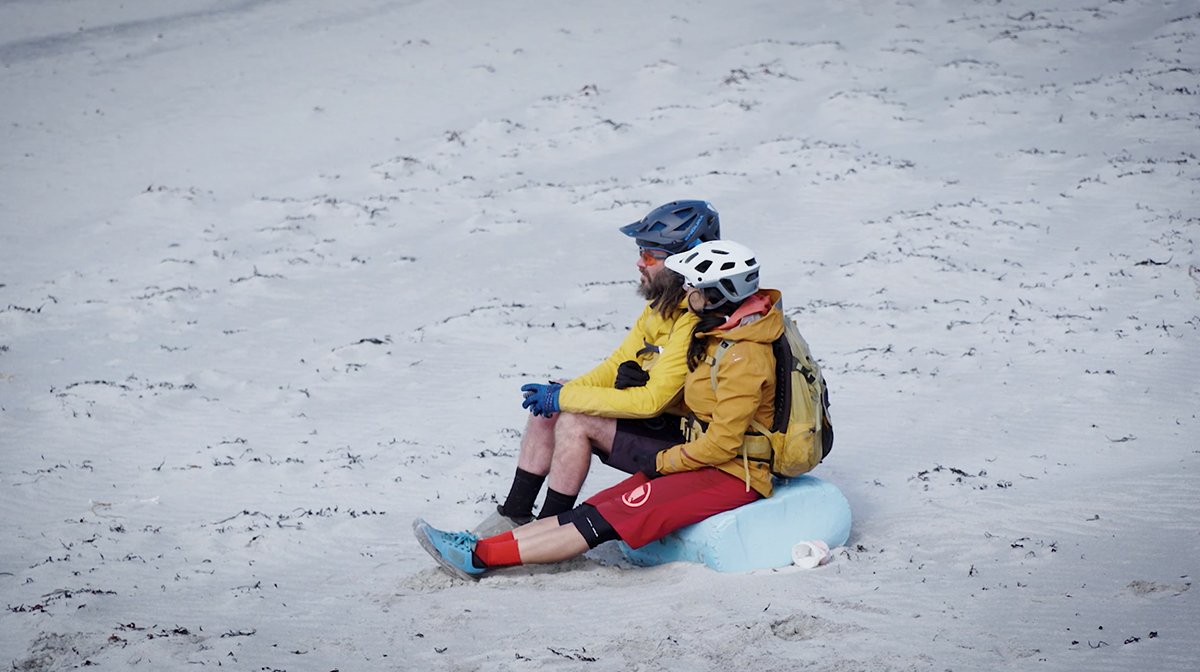 Endura athletes sit in the sand