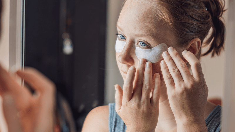 woman applying under eye patches