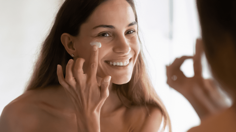 woman applying primer to face 