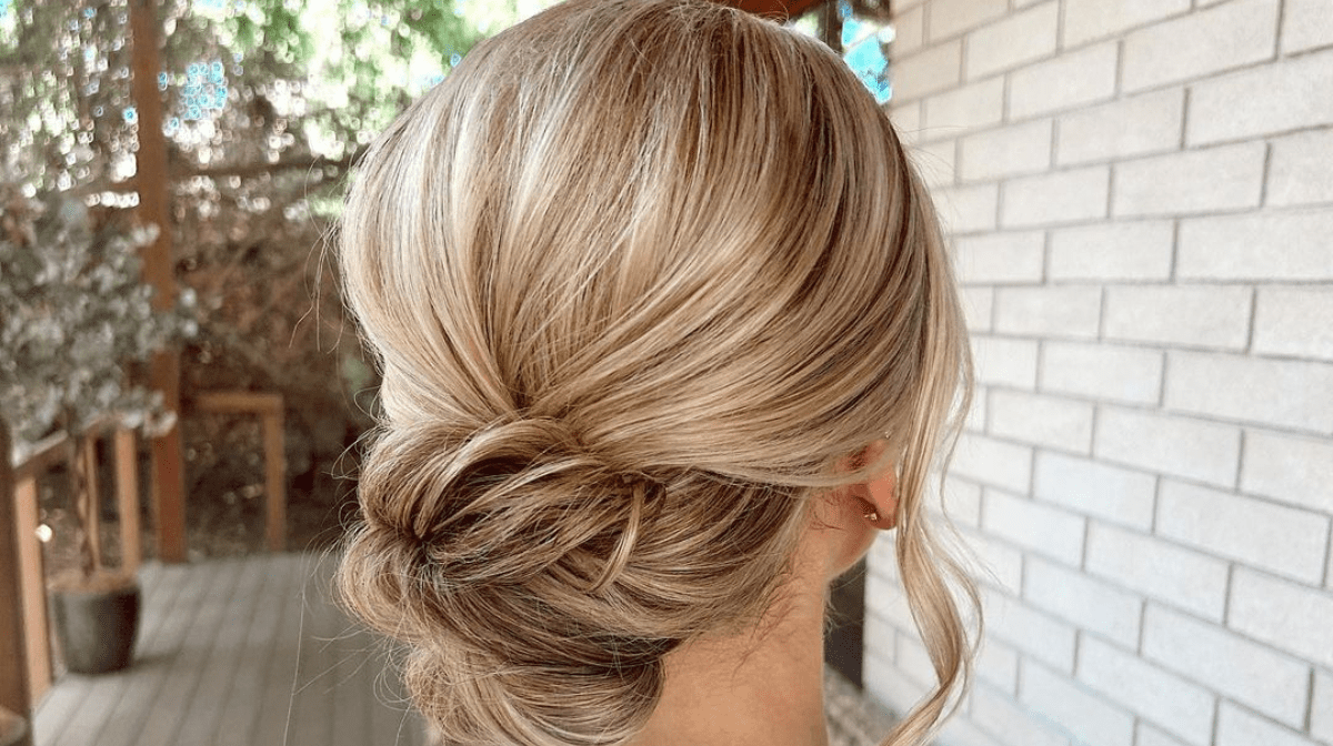 woman sat outside with a blonde low bun ready for her wedding
