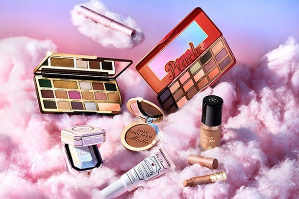 a collection of too faced products on pink clouds
