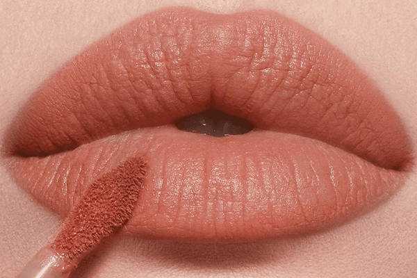charlotte tilbury nude blur on lips with the applicator on the lip