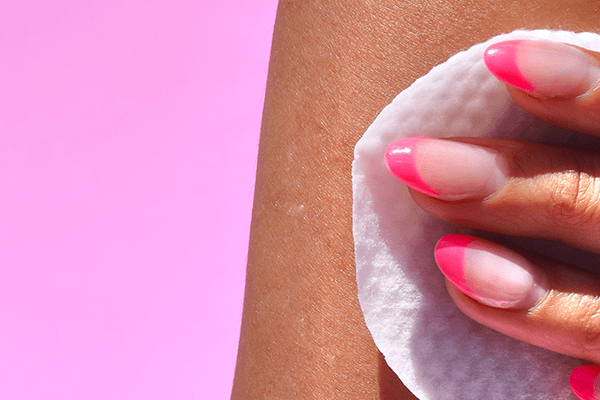 model with pink french manicure set using a kompari exfoliating pad on her skin