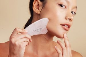 asian model using a gua sha on her face