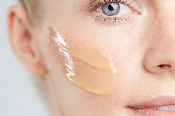 BLOND HAIRED MODEL WITH A YELLOW CLEANSER ON HER CHEEK