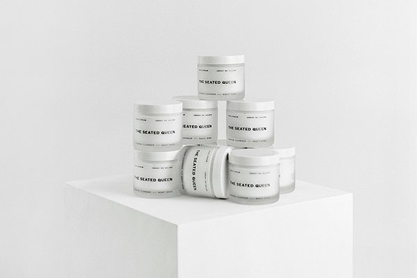 A range of The Seated Queen's Cold Cream product stacked on top of each other in a studio setting on a white background.