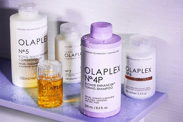 a collection of olaplex products wet shot in a shower shelf