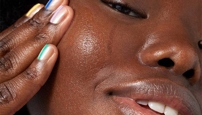 dark skin model showing her skin with multicoloured nails