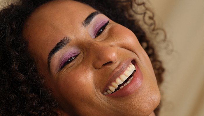 smiling female model wearing purple eyeshadow