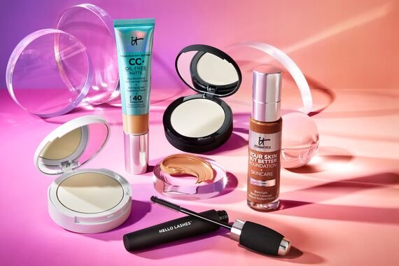 a collection of IT Cosmetics products against a pink and orange background