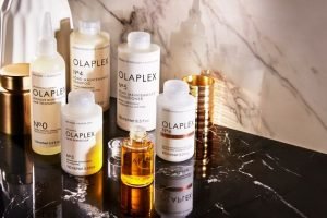 a collection of olaplex hair care products ontop of a black marble surface