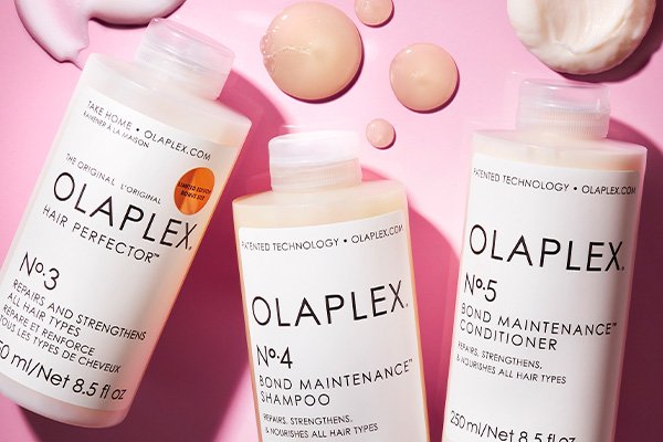 three olaplex products against a pink background
