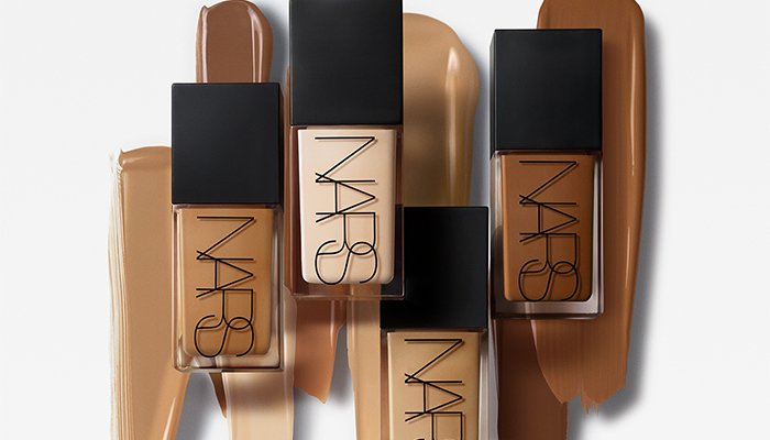 four shades of the NARS light reflecting foundation with swatches behind the bottles