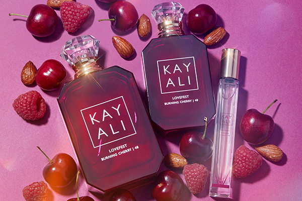 TWO BOTTLES OF KAYALI'S BURNING CHERRY PERFUME SURROUNDED BY CHERRIES