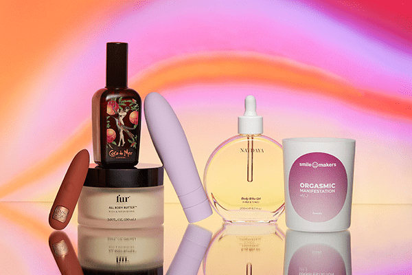 a collection of products including lube. sex toy, candle and body oil against a pinky/purple background