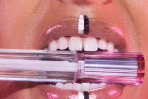 model with a lipgloss in her mouth 