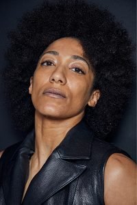 model with an afro looking into the camera