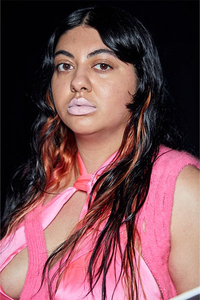 model with wearing pink with orange streaks in her hair and messy wavy hair