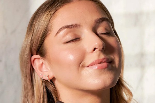 model with her eyes closed and super glowy skin