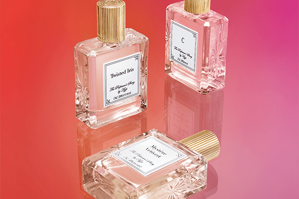 three bottles of the perfumers story shot in a studio on a pink background